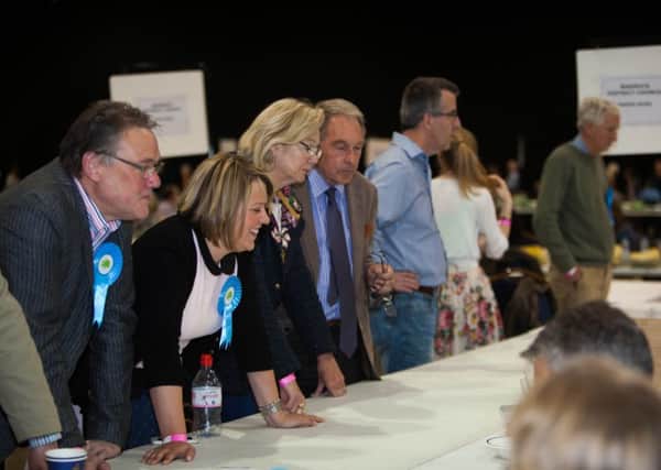 Candidates look on as votes are counted