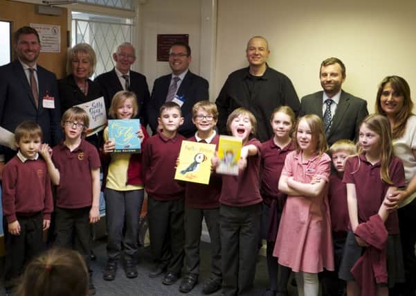 Children at St Paul's Primary School show off their new library books.
