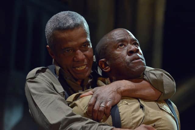 Othello (Hugh Quarshie) in an agressive clench with Iago (Lucian Msamati)
