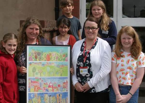 Milverton Primary School pupils present their artwork to Gayl Tallis from ehB Residential.