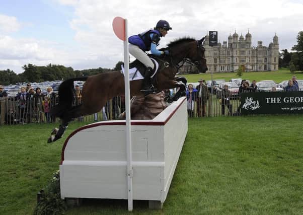 Jodie Amos tackles one of the obstacles during the cross country section of the Land Rover Burghley Horse Trials.