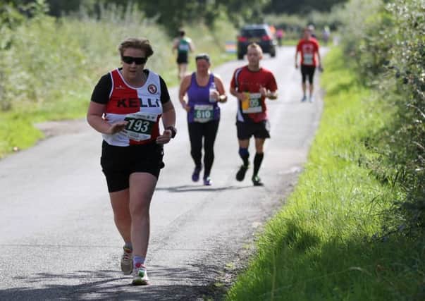 Massey Ferguson's Kelli Boyde passes the four-mile mark at the Kenilworth Half Marathon as race winner Andrew Siggers heads the other way with just four miles remaining. Pictures: Tim Nunan