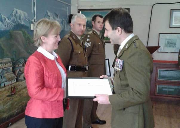 Helen Powell receives the award from Brigadier Coles