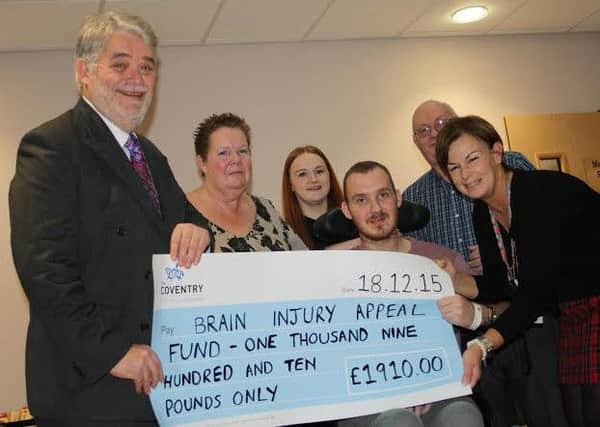 Stephen Collins (sitting), his boss Jeff Scott and family members present the donation to Sue Bleasdale from CERU.