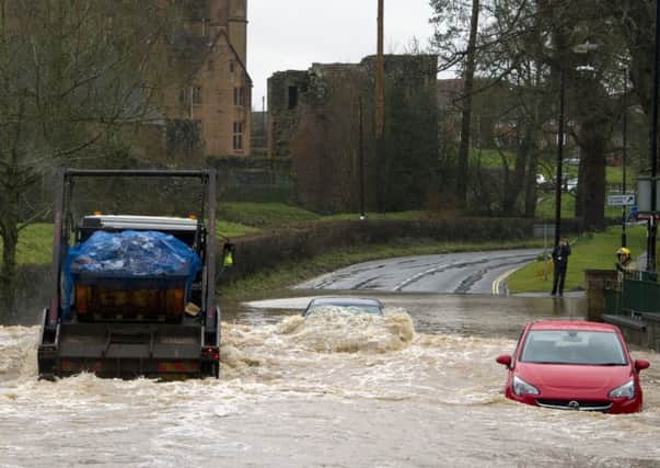 A lorry creates a wave as it drives through the ford, which engulfs a nearby car. Copyright: Fraser Pithie
