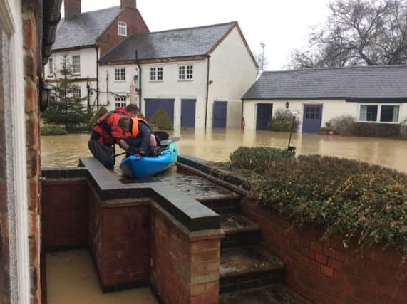 Dr Wyse and daughter Lara, setting off from their home in the kayak. Underneath the torrent of water in the picture is a swimming pool.