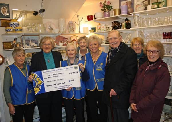 Val Stene and Raymond Macdonald of De Montfort Talking Book Service receive the cheque from a group of Kenilworth Lions volunteers.