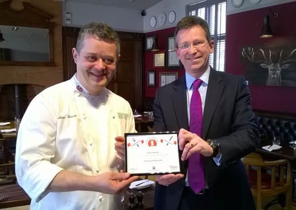 Adam Bennett holding the certificate for being a finalist in the Parliamentary Pub Chef of the Year competition alongside Jeremy Wright MP