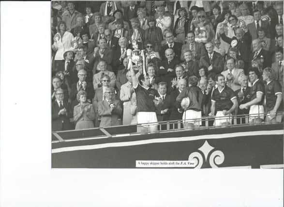 Mick Preston holding the FA Vase aloft after receiving it from Tom Finney, celebrating VS Rugbys triumph at Wembley in1983