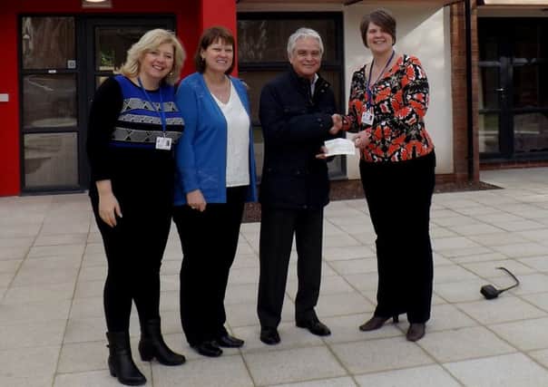 Ian Southcote presents the cheque to New Directions staff members.