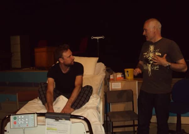 Pete Gillam on the bed, taking advice from director Rod Wilkinson in rehearsals