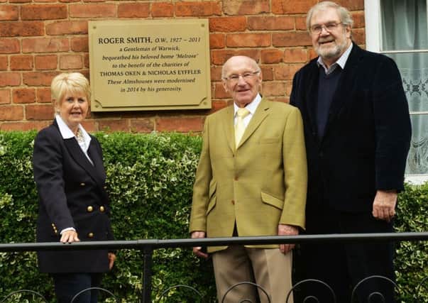 Standing by the commemorative wall plaque to Roger Smith outside the  Warwick almshouses are Thelma Atkins, chairman of the almshouses sub-committee of the Thomas Oken Trust, Alan Sturley and Terry Brown.
