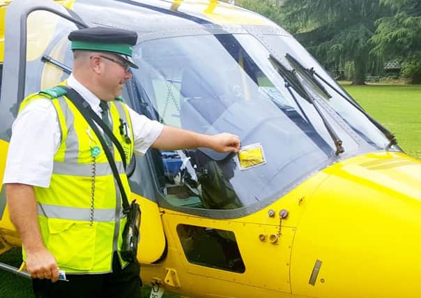 A traffic warden was pictured slapping a parking ticket on an air ambulance as a joke NNL-160408-151655001