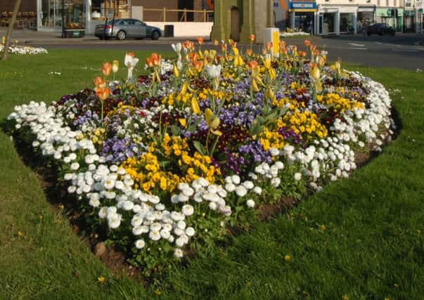 Flowers on the roundabout by Kenilworth's bus station and clock at the top of Warwick Road