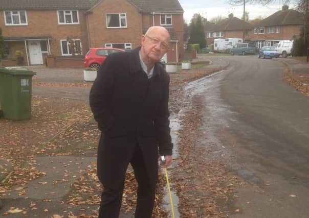 David Saul points out the ater leak in the road in Price Road, Cubbington.