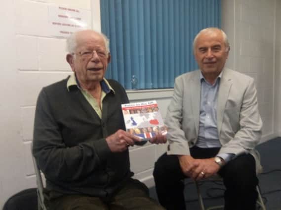 Jan Mokrzycki showing off his book Poles in the UK with Cllr John Whitehouse.