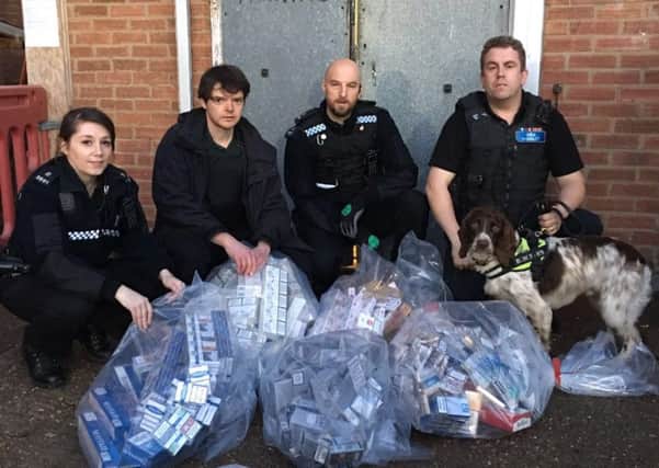Warwickshire Trading Standards, Warwickshire Police and sniffer dog handler with some of the seized cigarettes (from left to right Special Sergeant Sarah Adams (3891), Simon Cripwell Trading Standards Officer, Special Sergeant John-Paul Nelson (3912), Stuart Philips, specialist dog handler B.W.Y Canine Ltd.
Photo by Warwickshire County Council