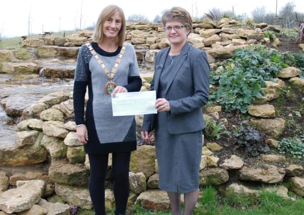 Rugby Sally Bragg receives a cheque from Chris Greer, Rugby Borough Councils senior bereavement services officer.