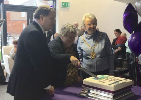 Kate Sayer cutting the cake for the official opening of Sayer Court, joined by Cllr Peter Philips and Chair of Warwick District Council Jane Knight.