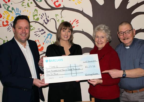 From left to right: Sam Funnell and Claire Heritage from Fine and Country donating money to Lilian Francis and Ian Gentles from Hope 4.