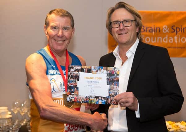 Peter Hamlyn, founder of the Brain and Spine Foundation handing David Phillips a certificate for raising Â£100,000 for the charity.