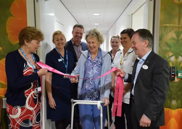 Castle Brook resident Audrey cuts ribbon held by WCS Care Chairman Karl Demian and SWFT Director of Operations Jane Ives to open the therapy building