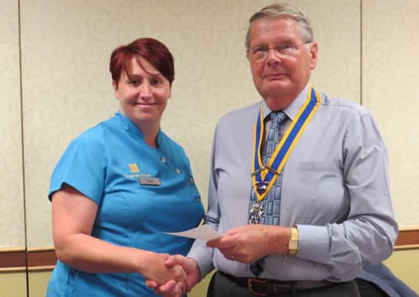 Warwick Rotary Club President John Taylor presenting Debbie Wall with a cheque for the Huntingtons Disease Association.