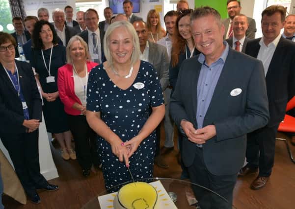 From left: Christine Asbury, WCS Care CEO, cuts the lightbulb cake at the launch with Ed Russell, WCS Cares Director of Innovation and Delivery, along with partner organisations and invited guests.