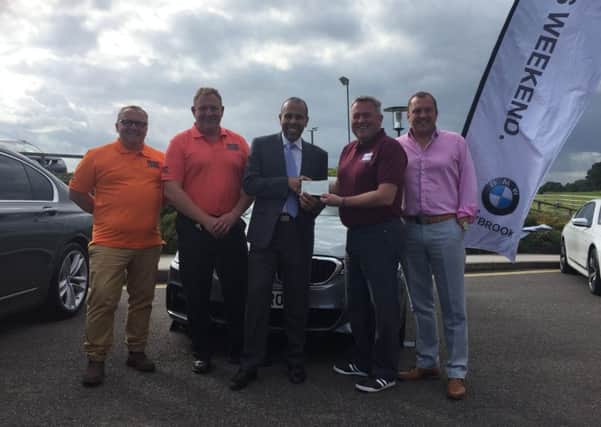 Lee Beacon , Dealer Principal at Rybrook Warwick BMW and lead sponsor of Rugby4Heroes presenting a donation cheque to Tony Lewis, father of Private Conrad Lewis, for Â£2,250. He is surrounded by members of the R4H volunteer team.