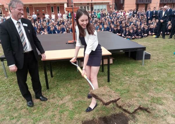 Alexandra Solt, the new head girl at King's High, digs a chunk out of the ground during the ceremony