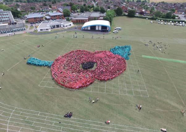 Residents, staff, volunteers and members of the local community came together to help create the human poppy.