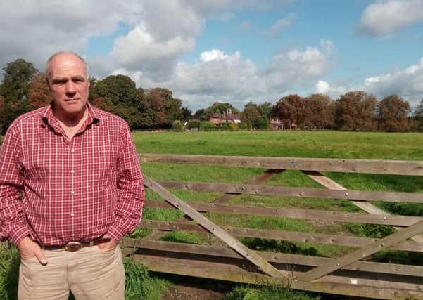 David Smith-Ryland at the field he owns in Barford with Barford Hill Stables in the background.
