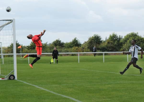 AEI goalkeeper Lubomir Sabol watches the ball fly over his goal with Whitnash's Dan Nelson